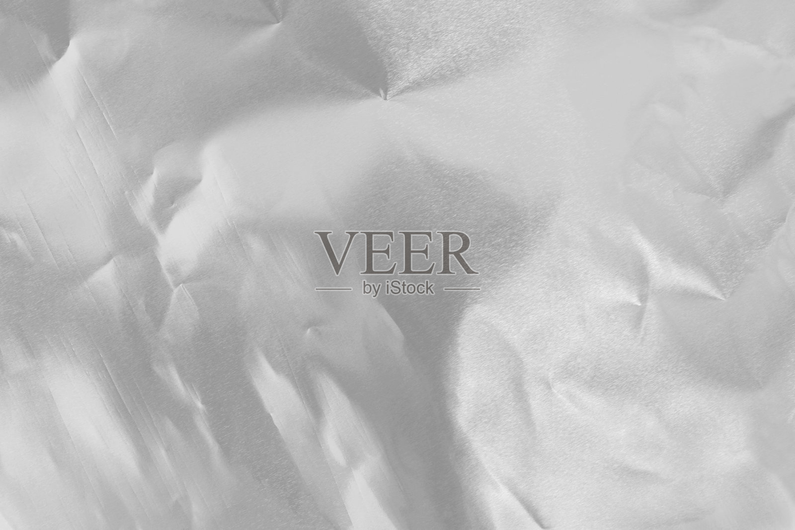 闪亮的银色箔纹理背景,皱褶和波浪状的包装纸图案。照片摄影图片