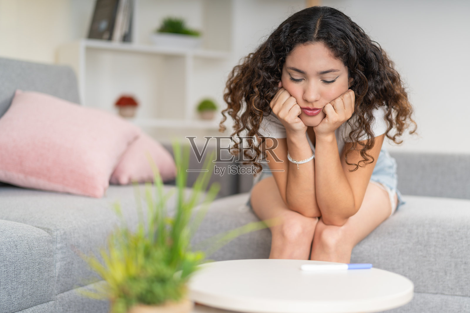 女孩在看桌子上的验孕棒照片摄影图片