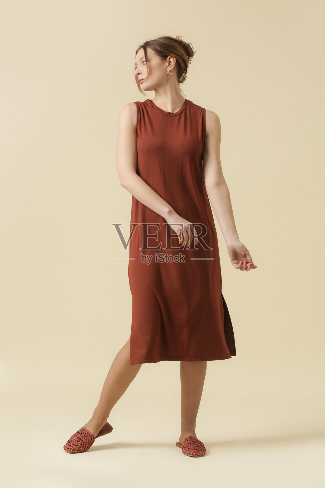 女性模特穿着棕色棉质夏季休闲裙。摄影棚拍摄。照片摄影图片