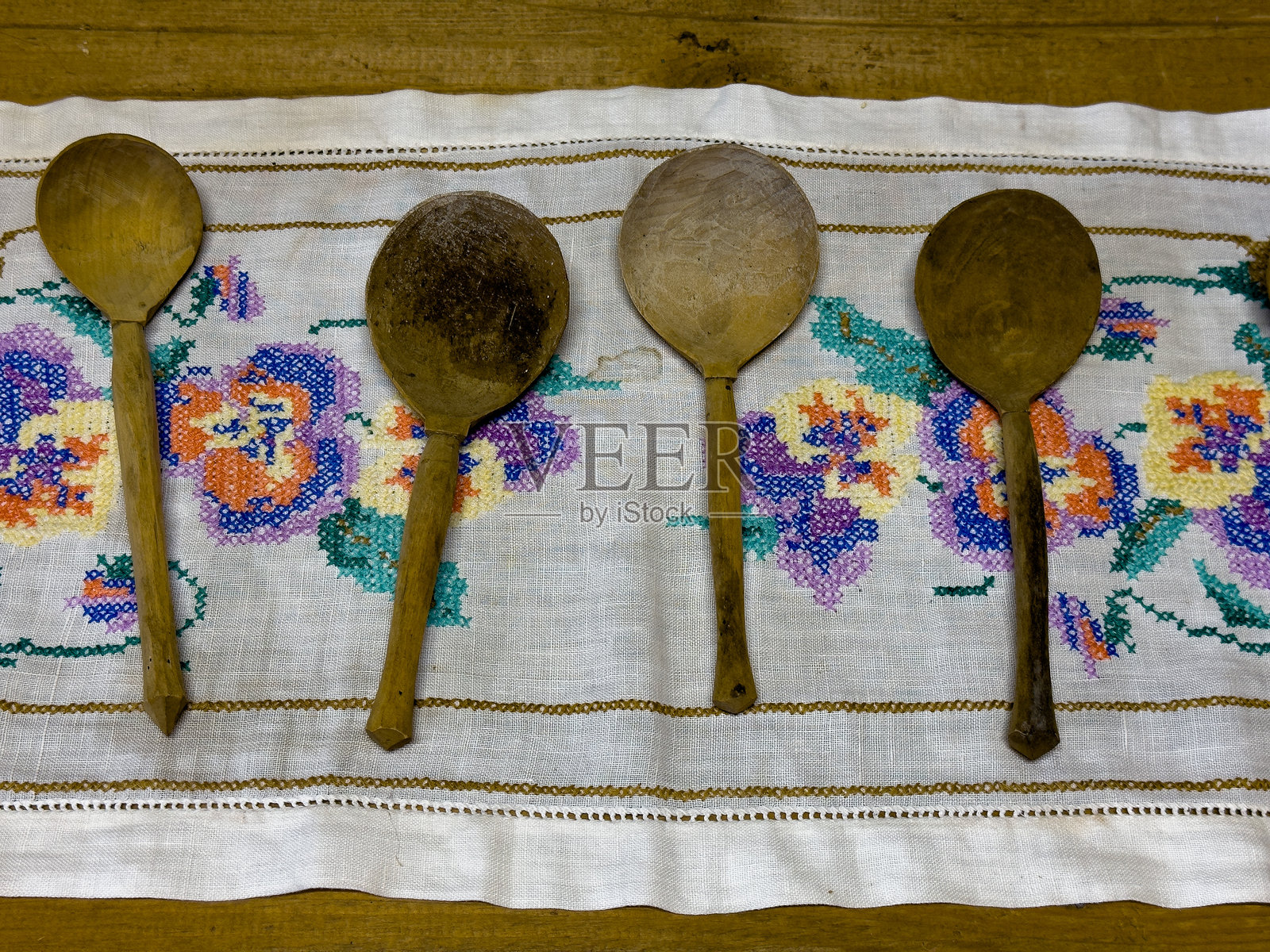 传统环境中刺绣布料上展示的乡村木勺照片摄影图片