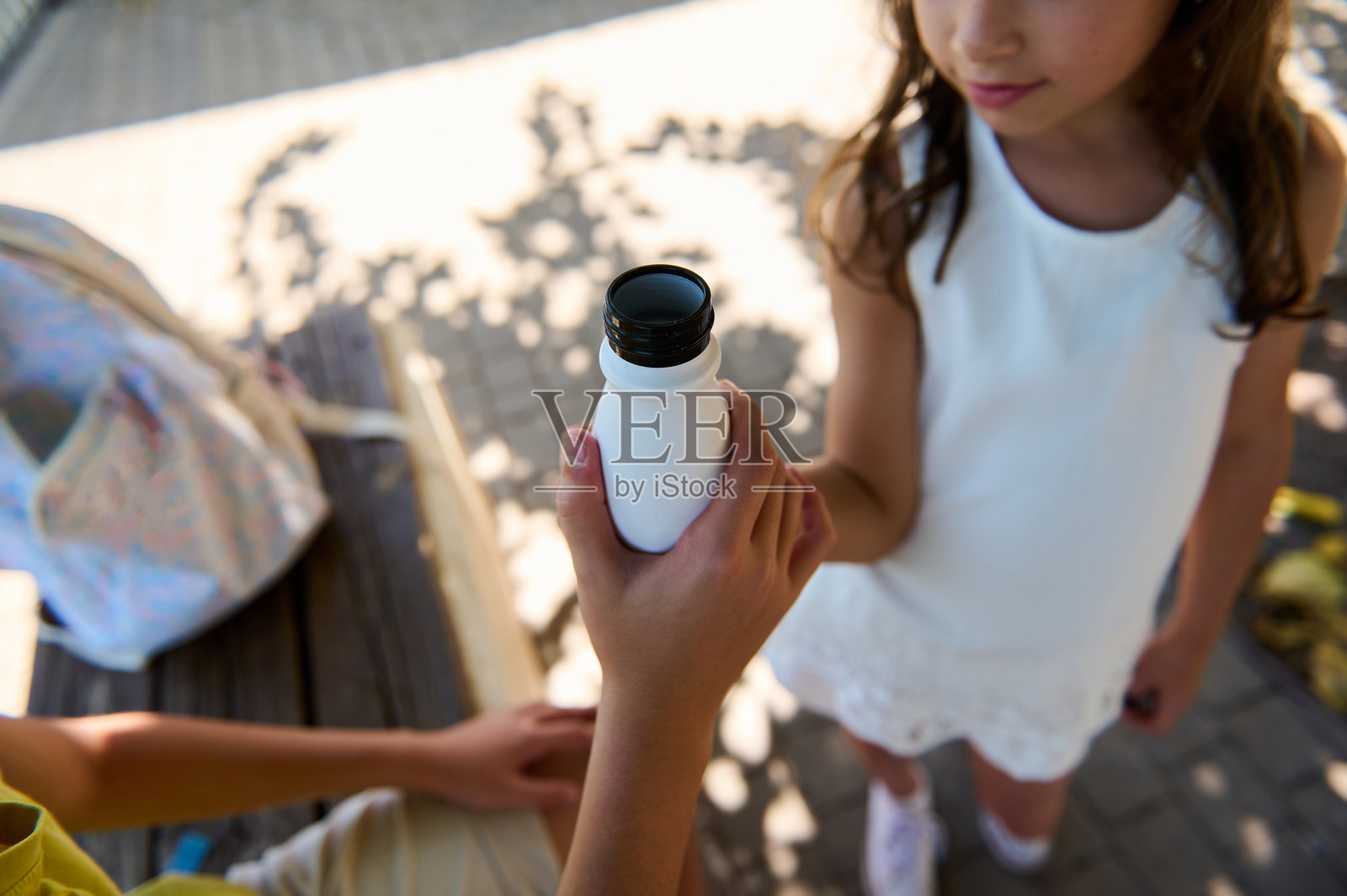 女孩在阳光明媚的日子里与朋友分享饮料照片摄影图片