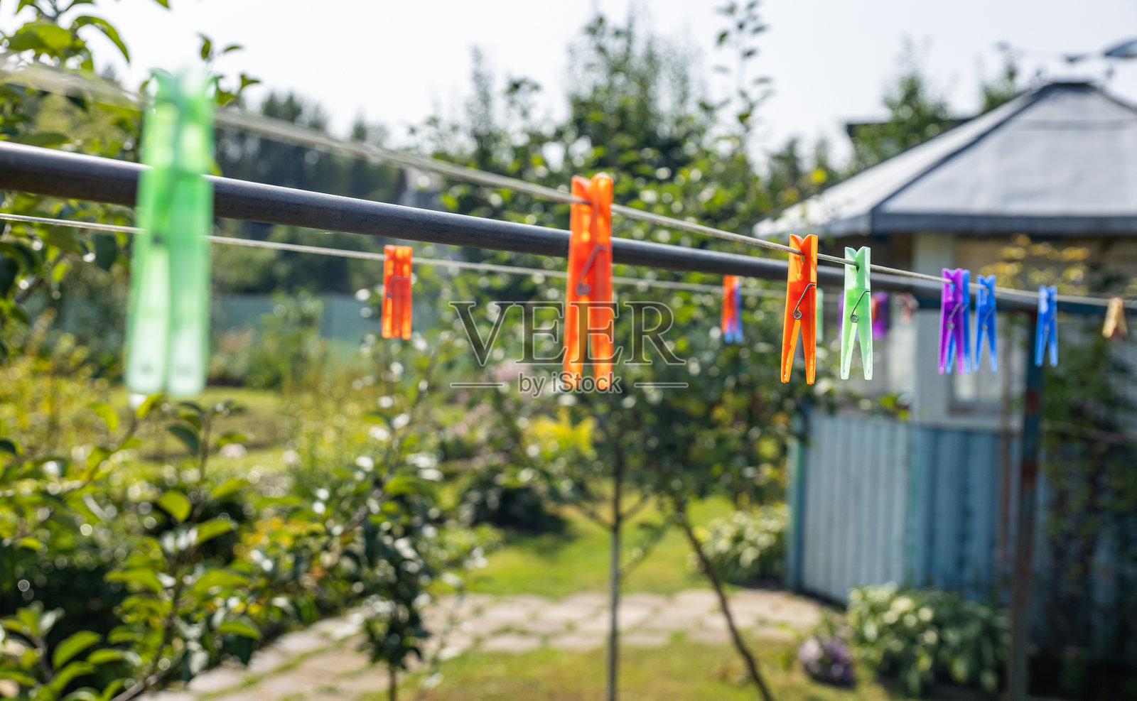 夏天晾衣绳上的衣夹。外面晾干的衣物。绳子上的衣服。照片摄影图片