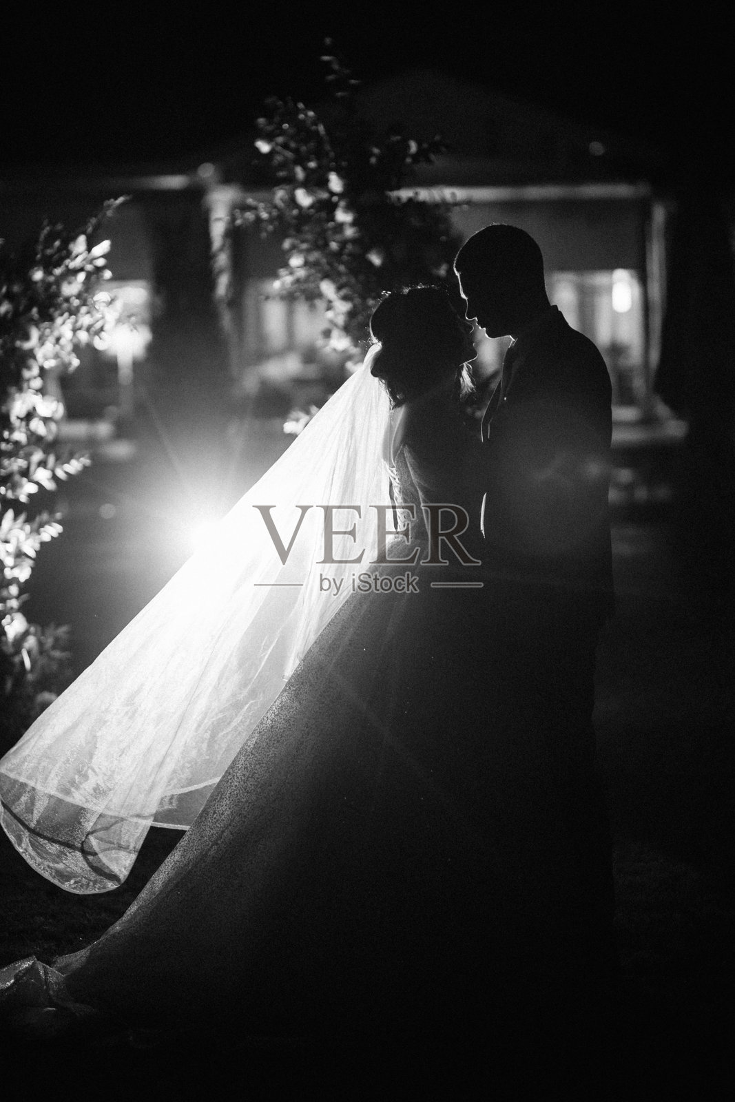 女孩和男孩在夜晚婚礼拱门的背景下照片摄影图片