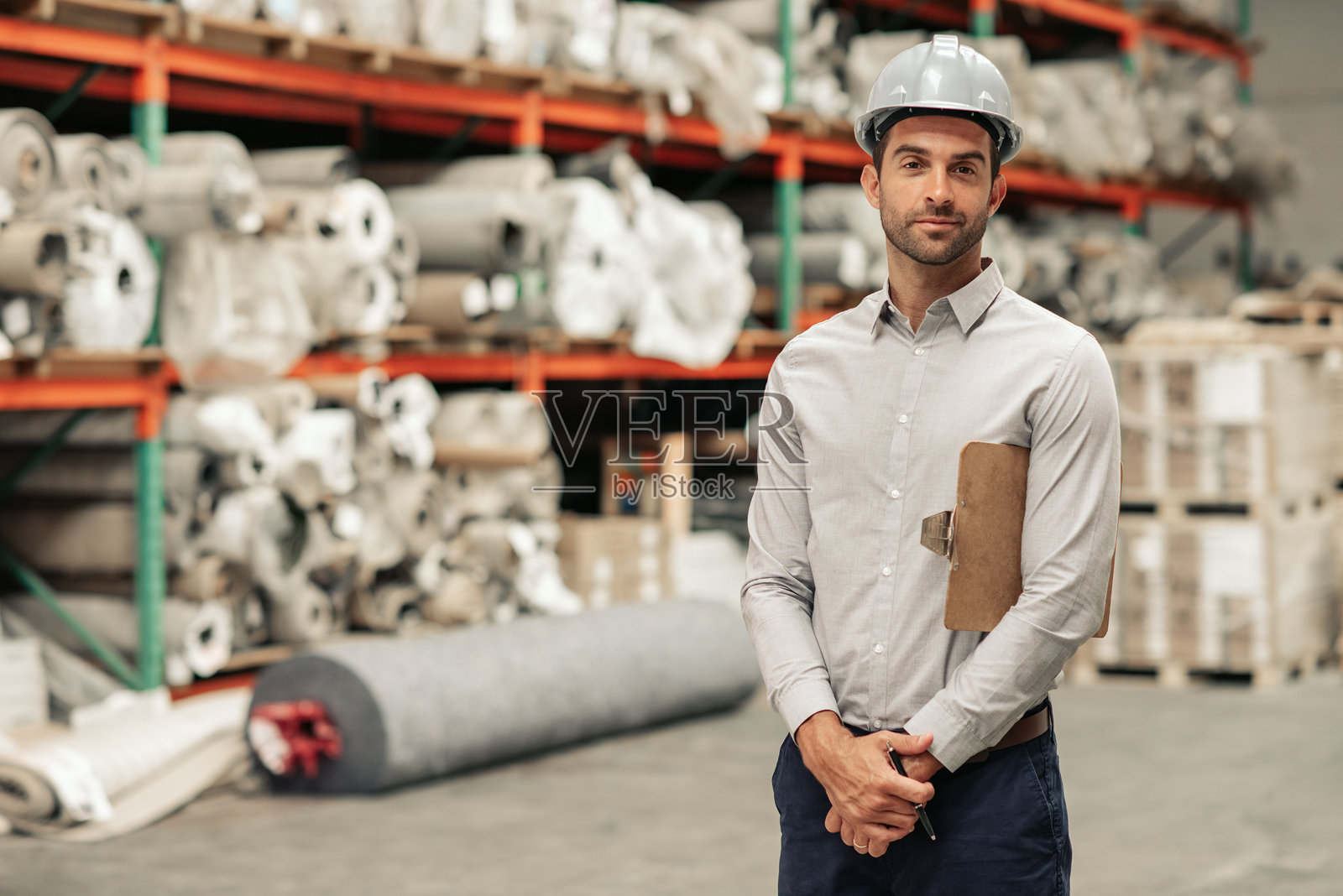 仓库主管戴着安全帽进行库存盘点照片摄影图片