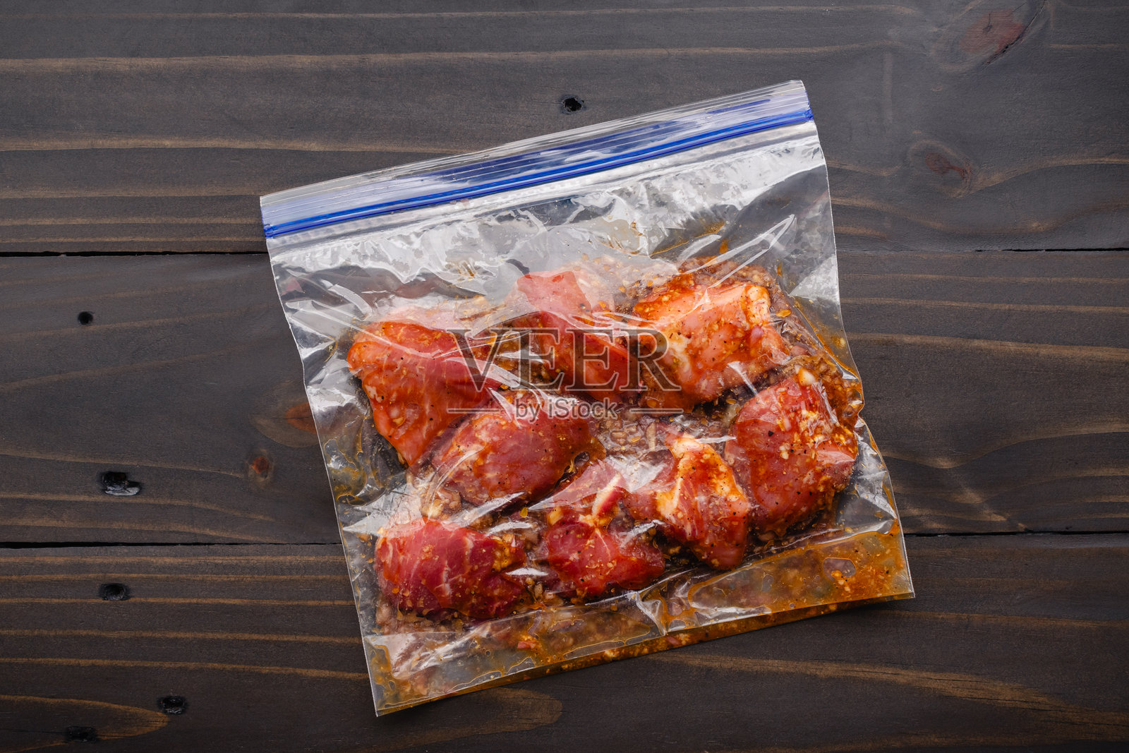 猪肩肉块在塑料袋中腌制照片摄影图片