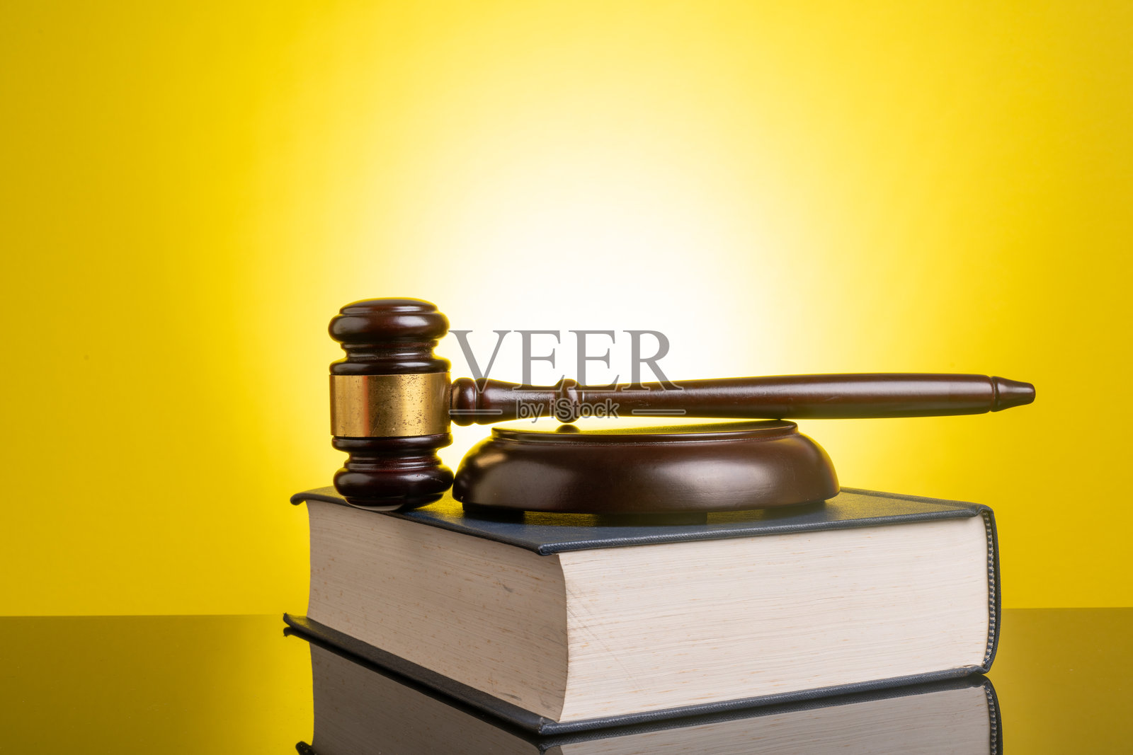 黄色背景上的法槌和书籍照片摄影图片