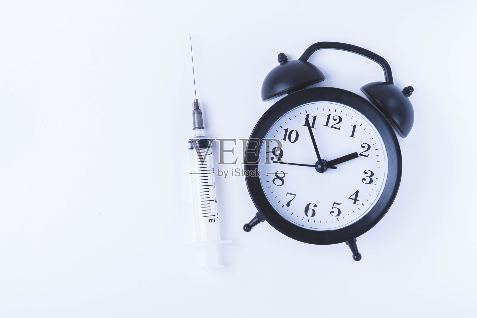 预防接种时间。手表和疫苗注射器。人群预防接种日期和时间。照片摄影图片