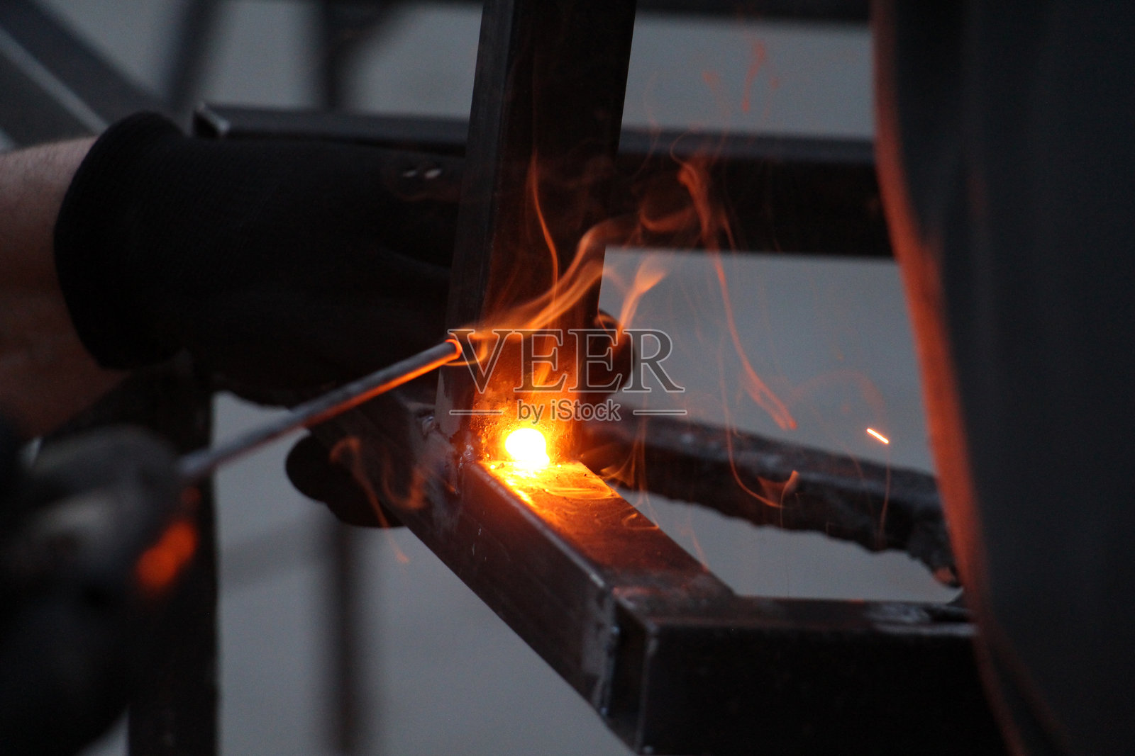 工厂中一名男子正在加工金属的手部特写照片摄影图片