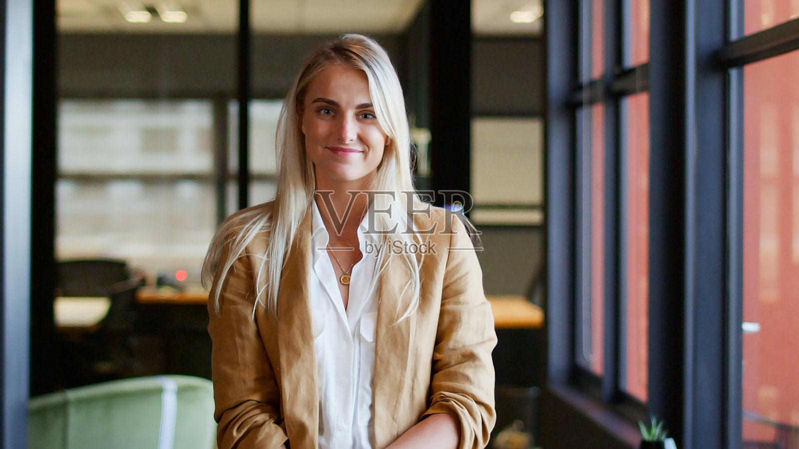 现代开放式办公室中微笑的年轻女商人肖像照片摄影图片
