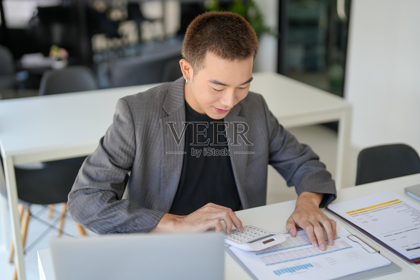 自信的亚洲商务人士,审计师或内部税务人员正在检查公司的年度财务报表,进行审计和税务会计。照片摄影图片