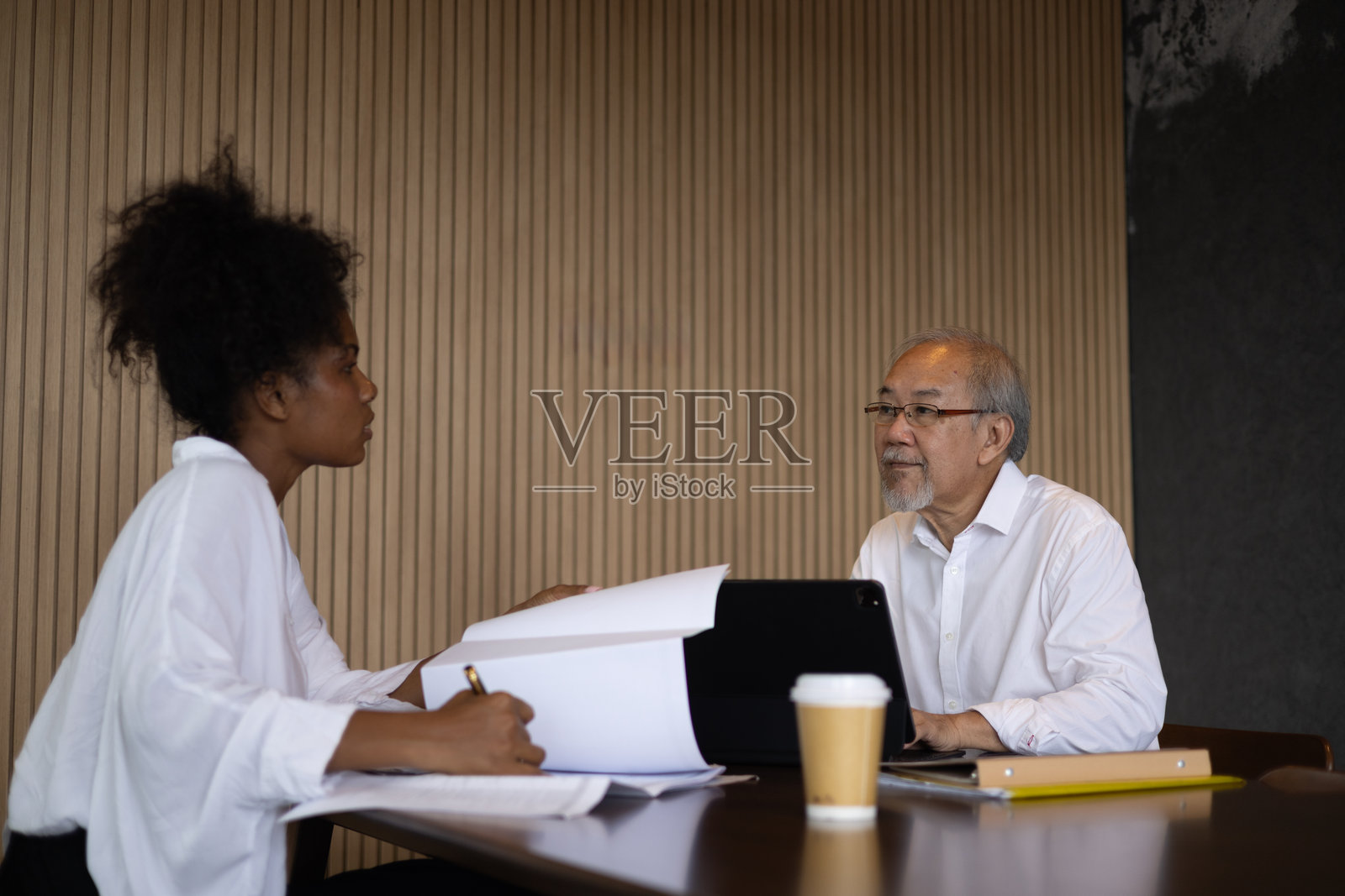 年长的经理和黑人女员工在办公室里用笔记本电脑协作照片摄影图片