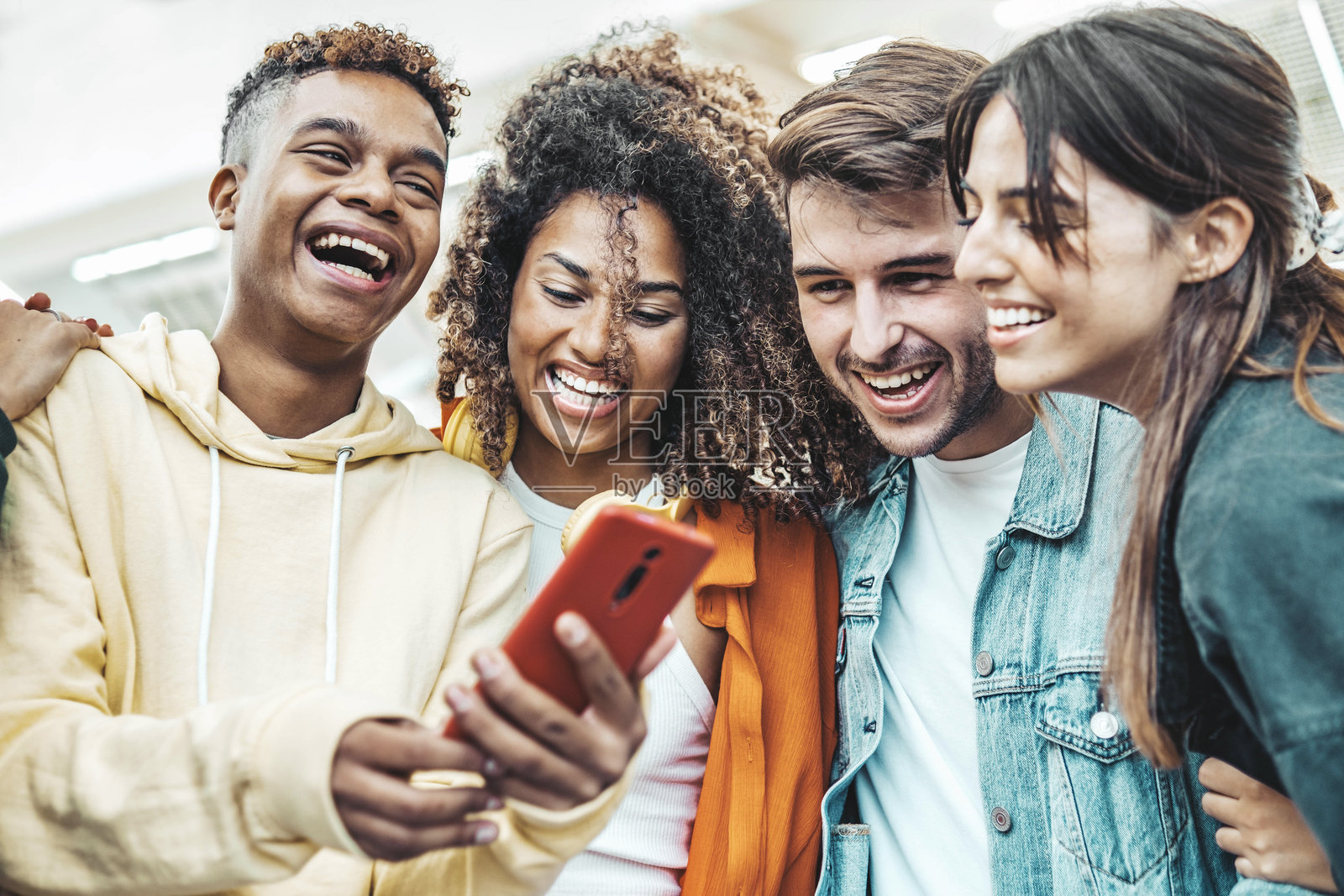 一群年轻人在户外使用智能手机 - 快乐的朋友一起用智能手机在社交媒体平台上观看有趣的视频 - 科技与现代生活方式概念照片摄影图片