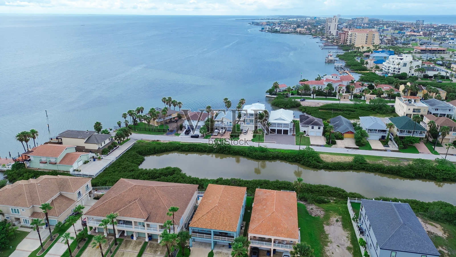 南帕德雷岛市中心及沿海湾的住宅社区,位于沿岸,豪华海滩别墅,带游泳池的豪宅,私人木栈桥和船坡道码头照片摄影图片