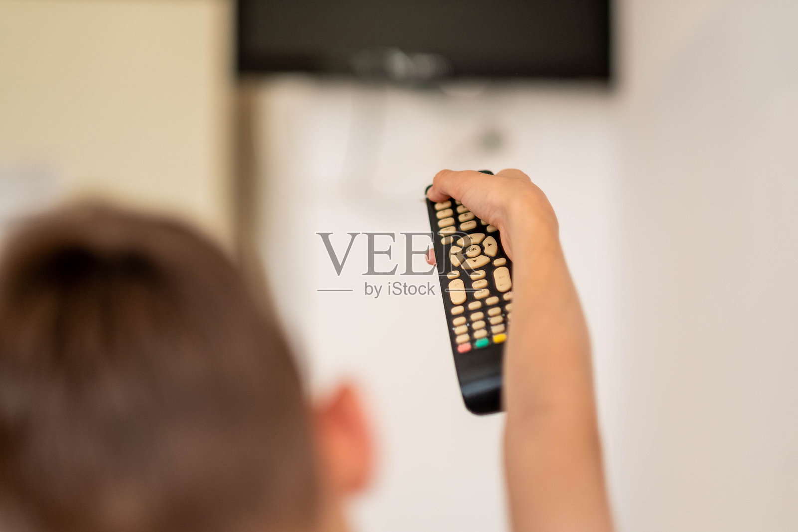 孩子的手拿着电视遥控器照片摄影图片