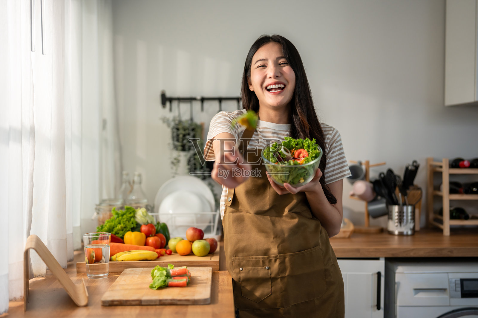 在厨房做绿色健康沙拉的亚洲女子照片摄影图片