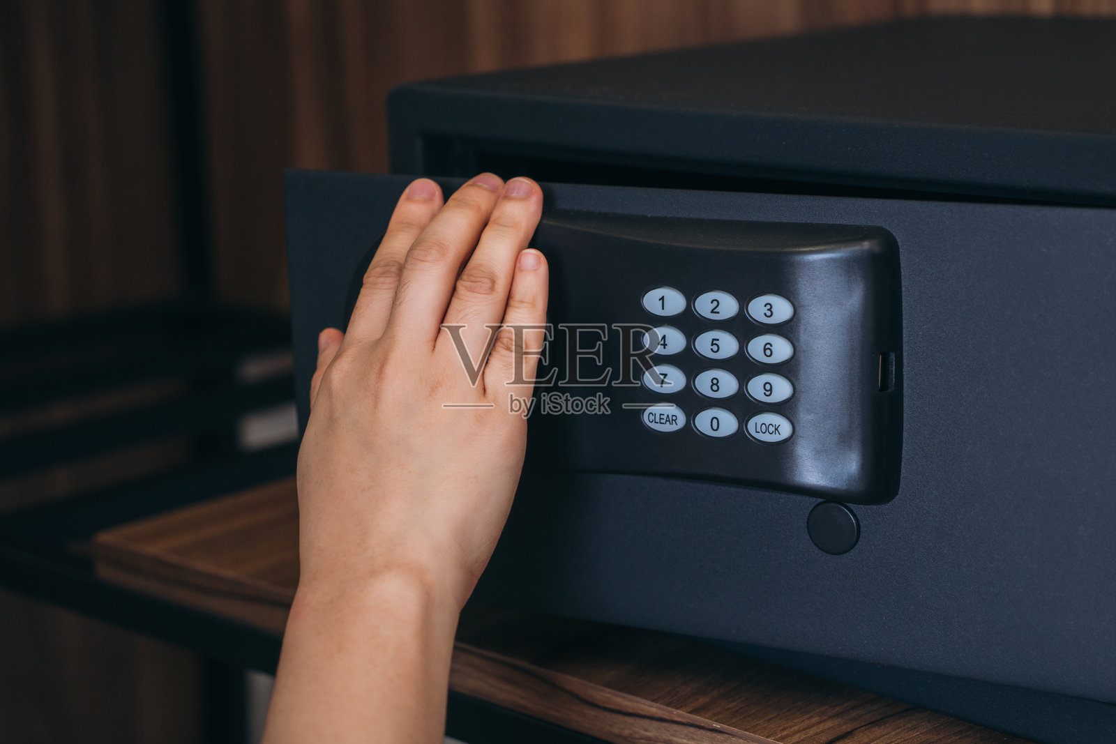 特写:手输入密码解锁保险箱门照片摄影图片