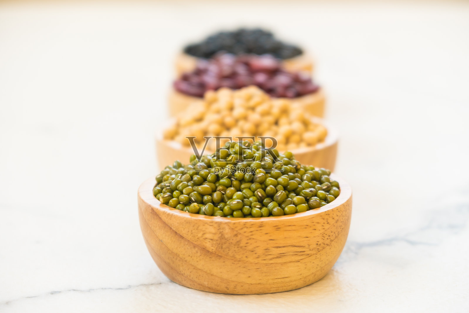 高角度视图下的各种豆类盛在碗中,背景为白色照片摄影图片