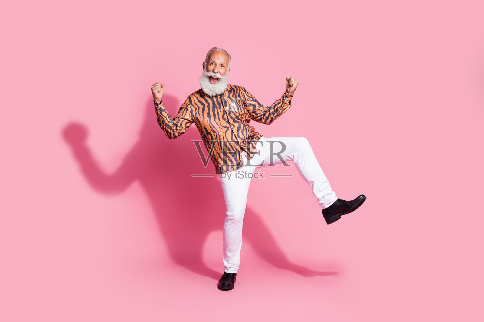 在柔和彩色背景下挥拳跳舞的活力老人照片摄影图片