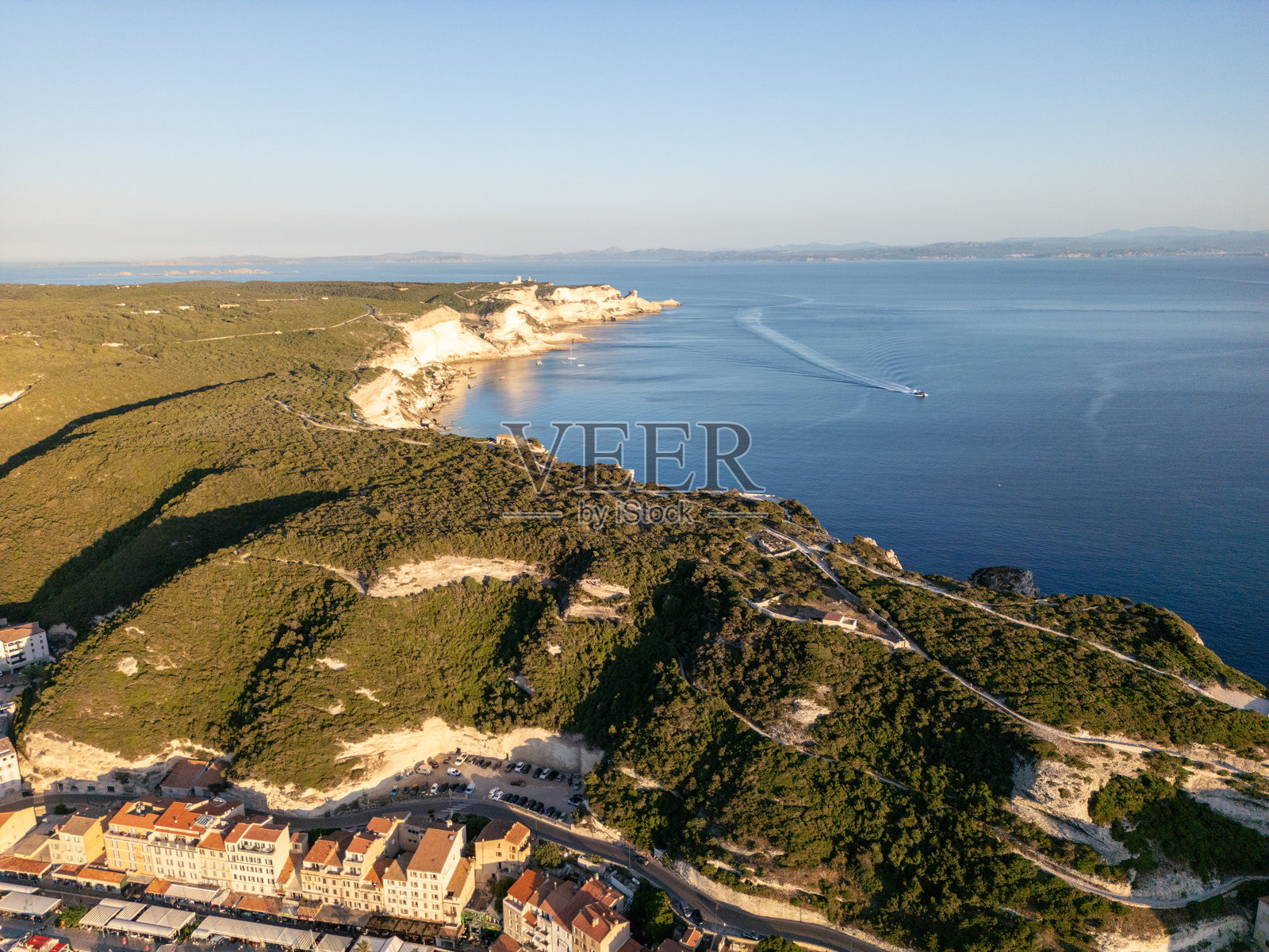 日落时分的海岸山丘和海洋的鸟瞰图照片摄影图片