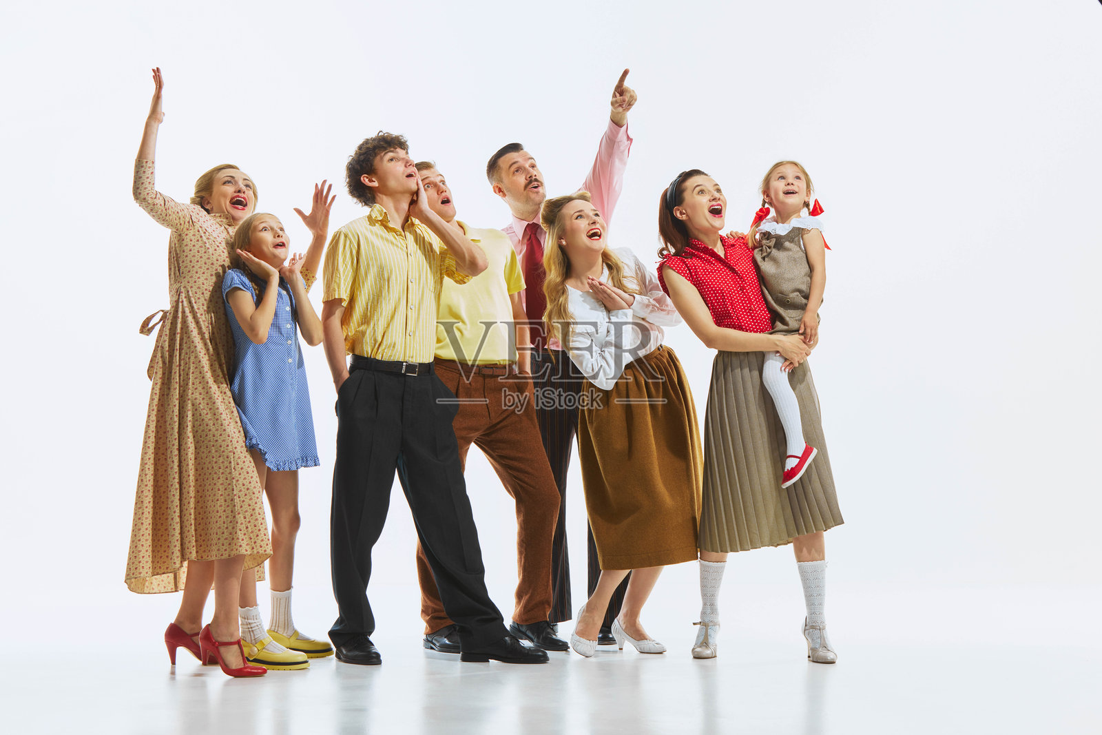 一群穿着复古服装的人指着上方,神情震惊而兴奋,背景为白色照片摄影图片