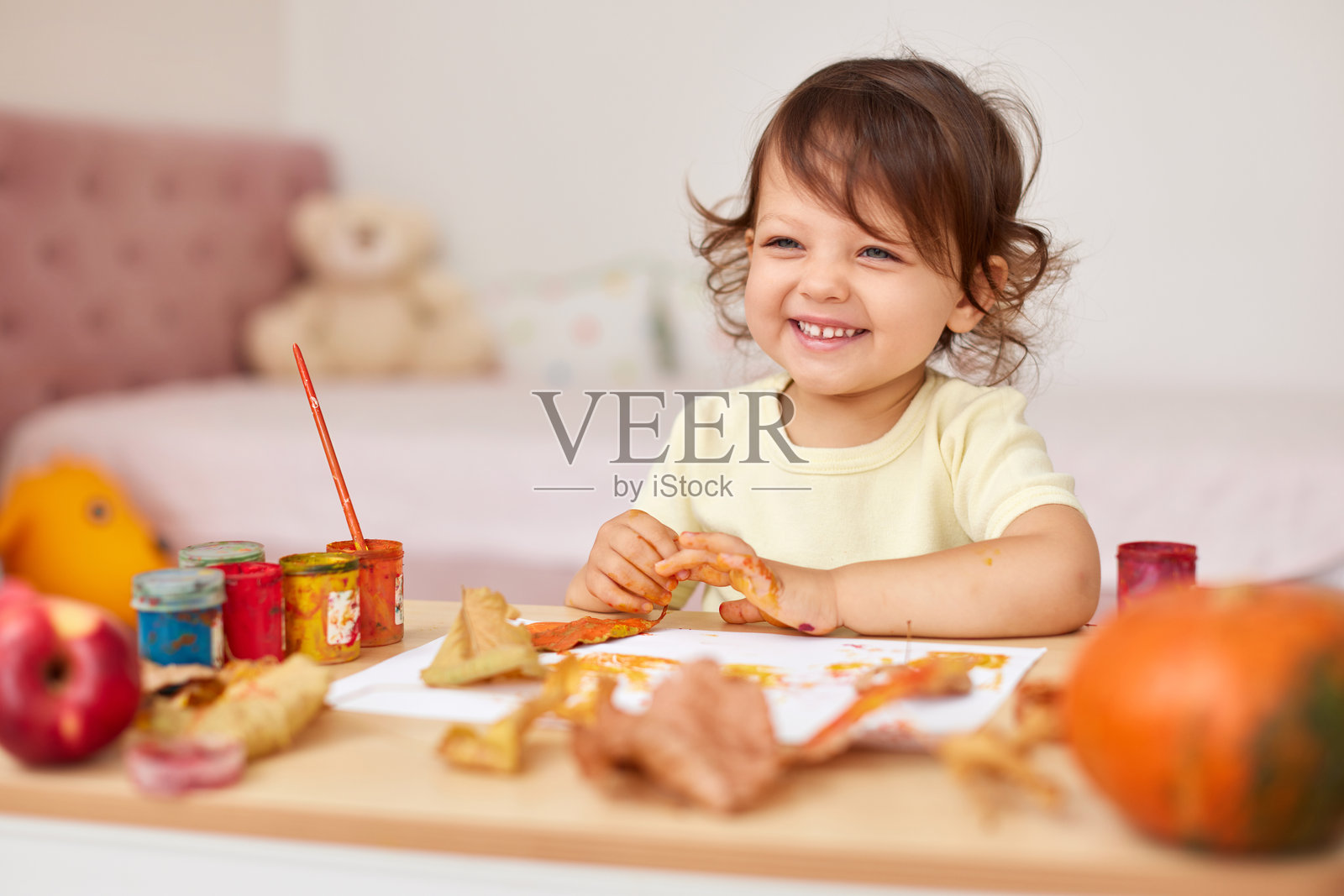 快乐的小女孩在画秋天的树叶照片摄影图片