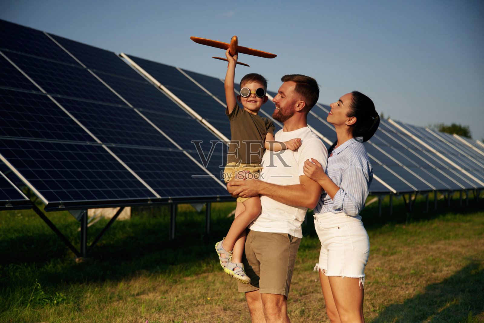 太阳能板旁玩耍的父子与玩具飞机照片摄影图片