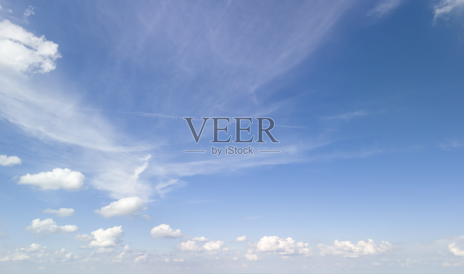 宁静的蓝天上点缀着柔和的白云,传达出一种宁静和开阔的感觉。非常适合用作各种设计的背景。照片摄影图片