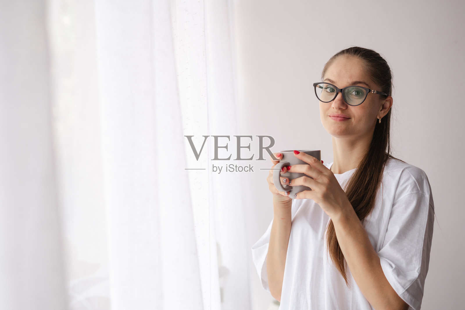 戴眼镜的女人手握早晨咖啡杯照片摄影图片