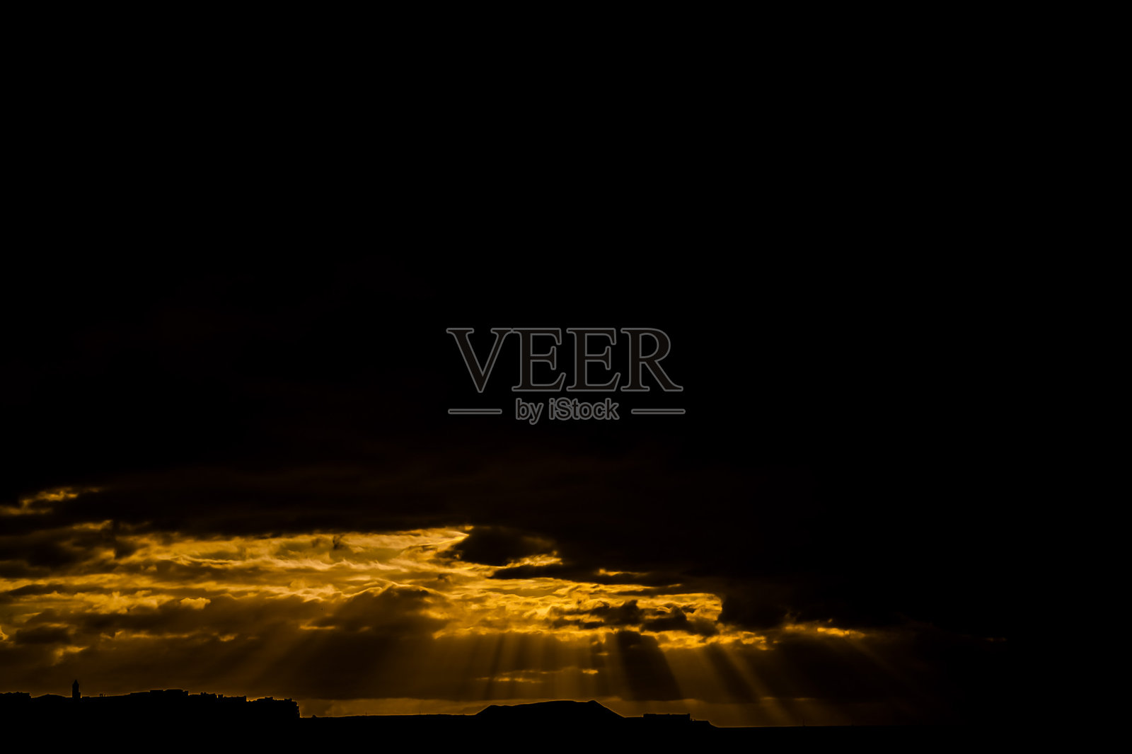 天空阴暗,阳光透过云层照射下来。照片摄影图片