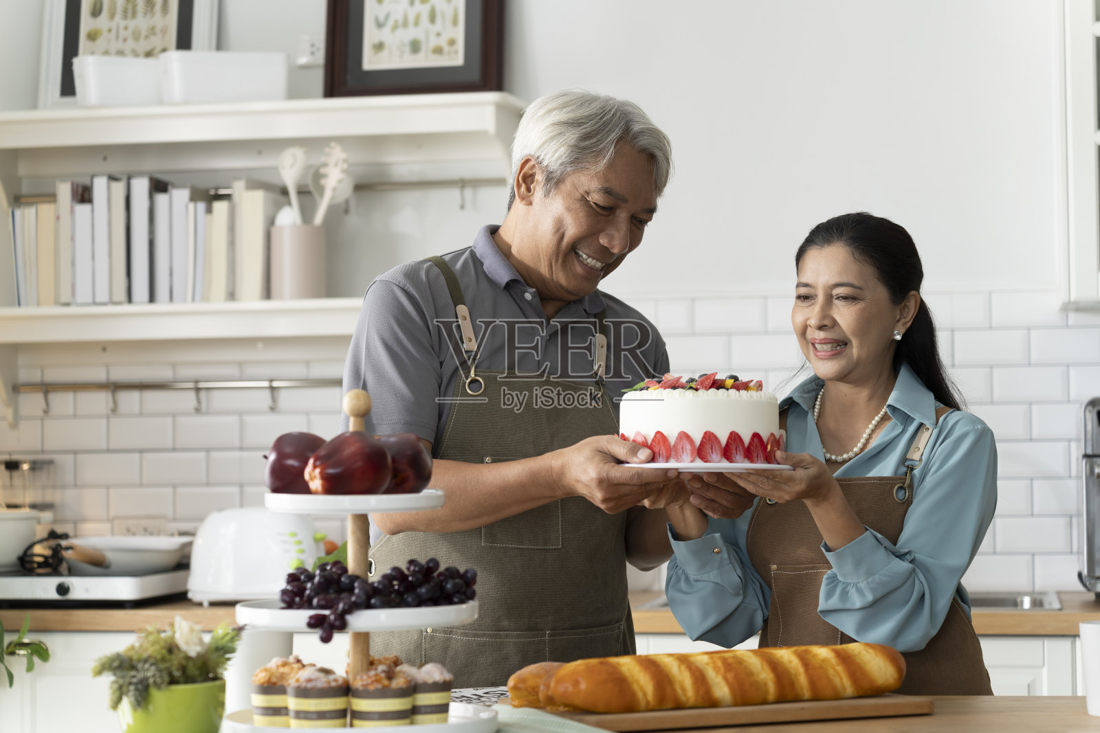 老年夫妇在厨房庆祝自制蛋糕照片摄影图片