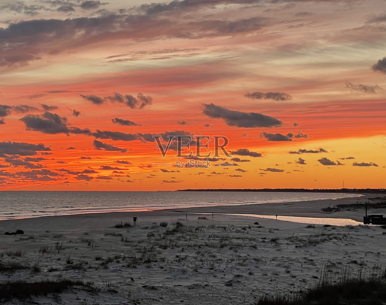 海滩日落,橙色、黄色和粉色的色调与云彩相映成趣照片摄影图片