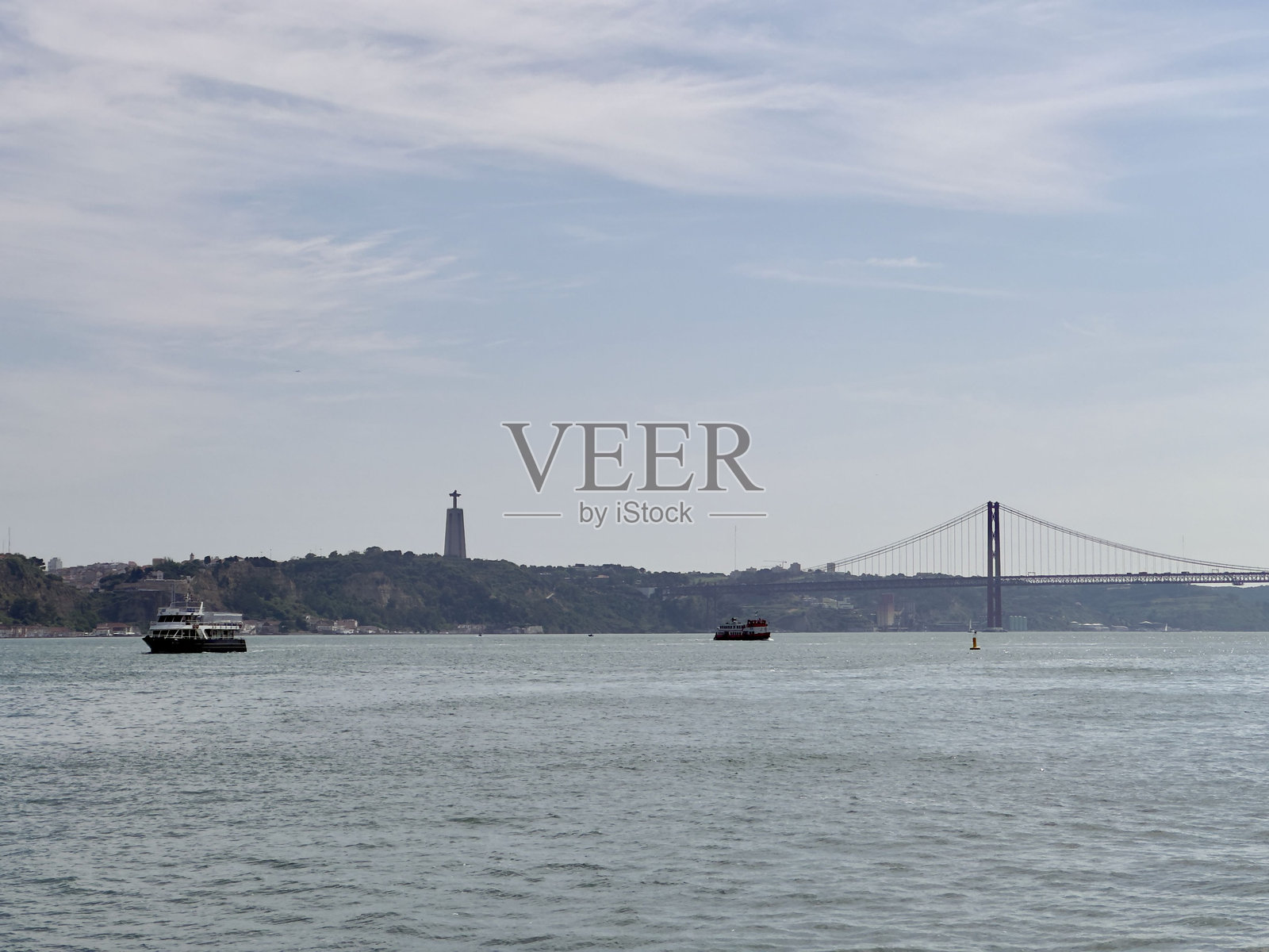 里斯本的塔古斯河,背景是基督王圣殿和25号四月大桥照片摄影图片