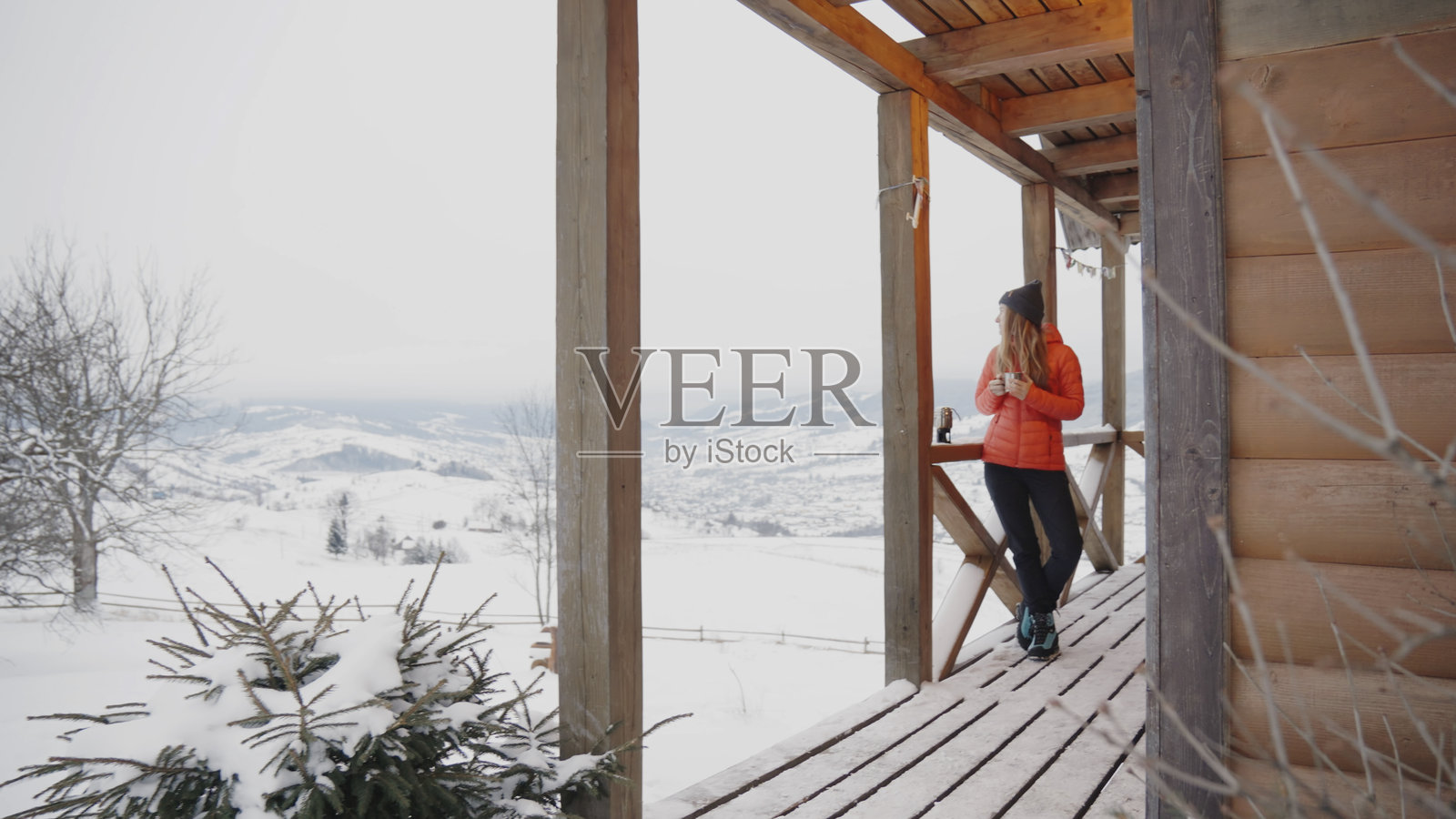 年轻女性在冬季准备远足,享受热饮。照片摄影图片