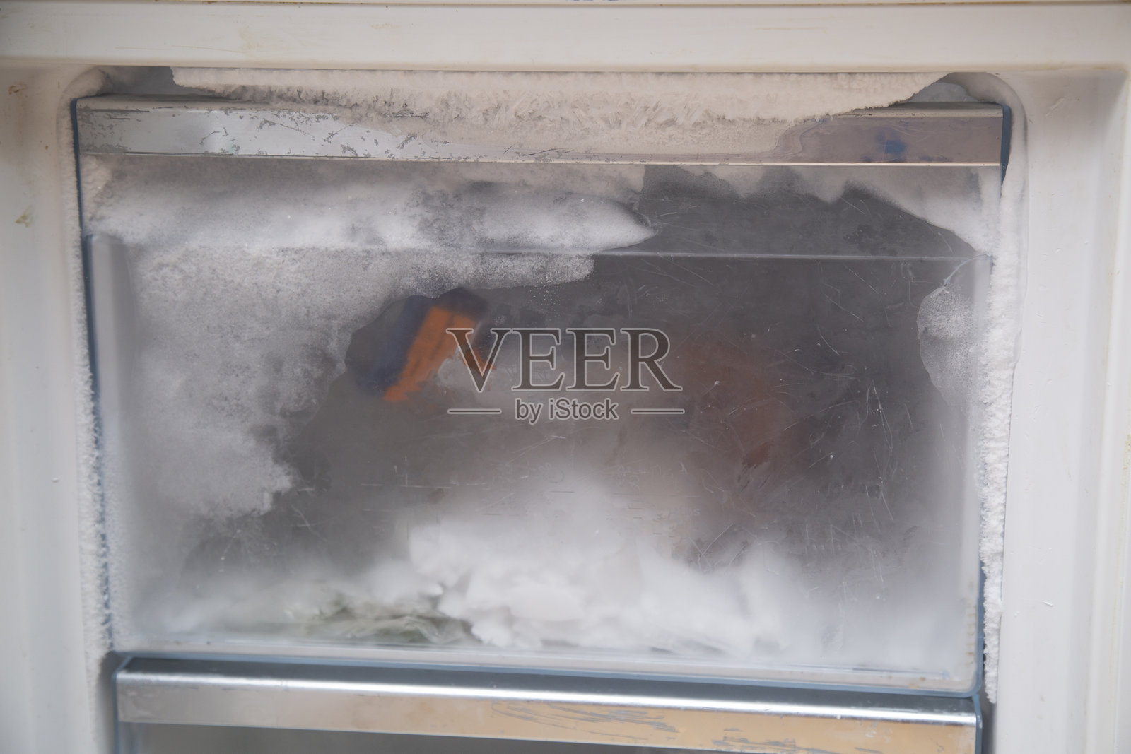 冰箱结冰了。清理冰箱里的冰。照片摄影图片