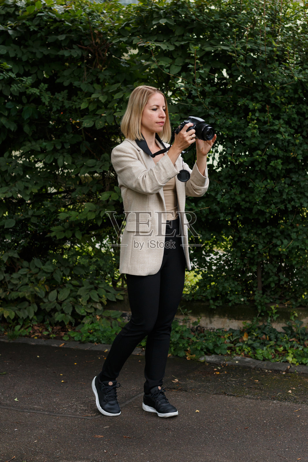 女性在户外用单反相机拍照照片摄影图片