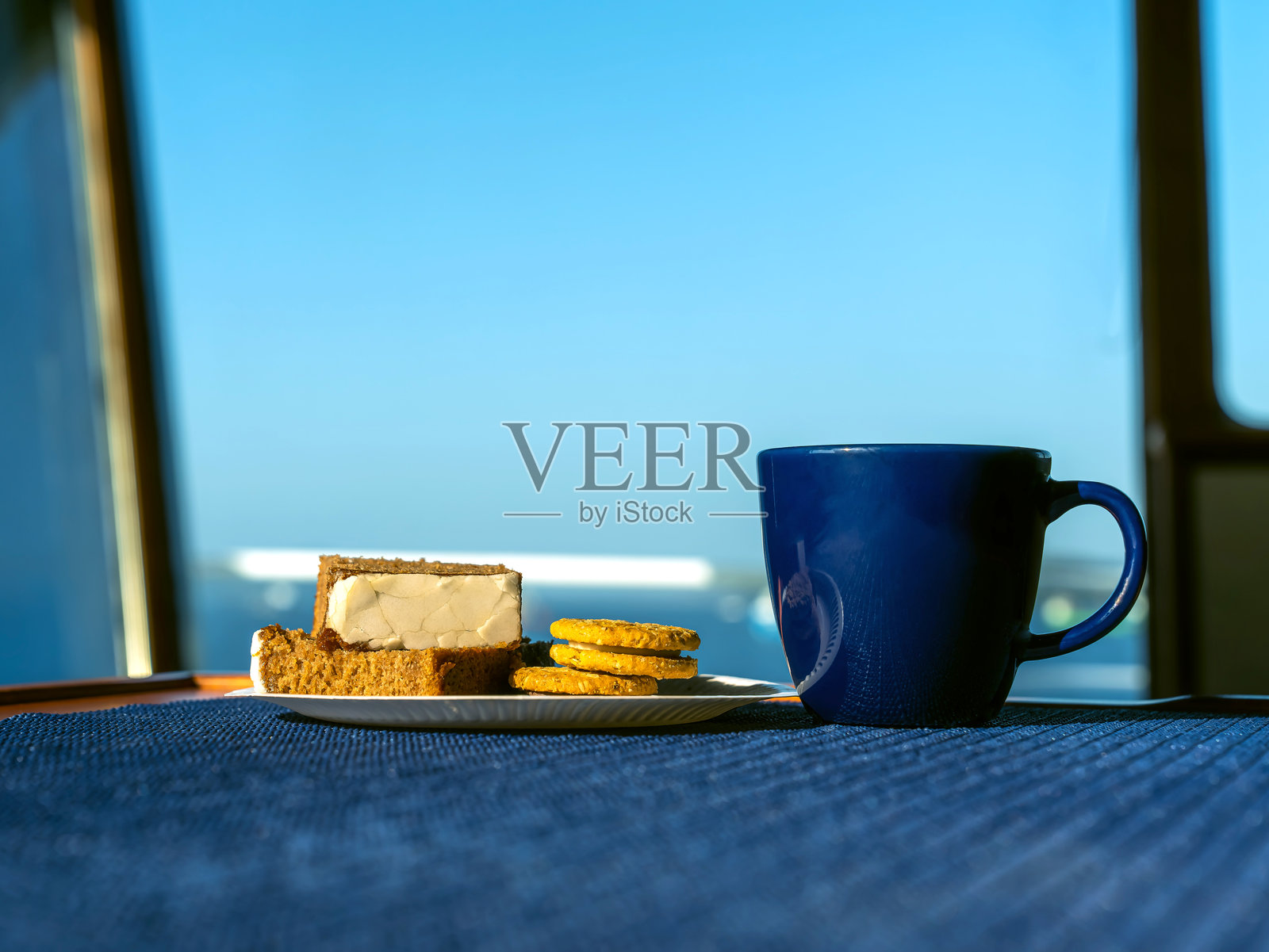 桌子上放着一杯咖啡和几块饼干。照片摄影图片