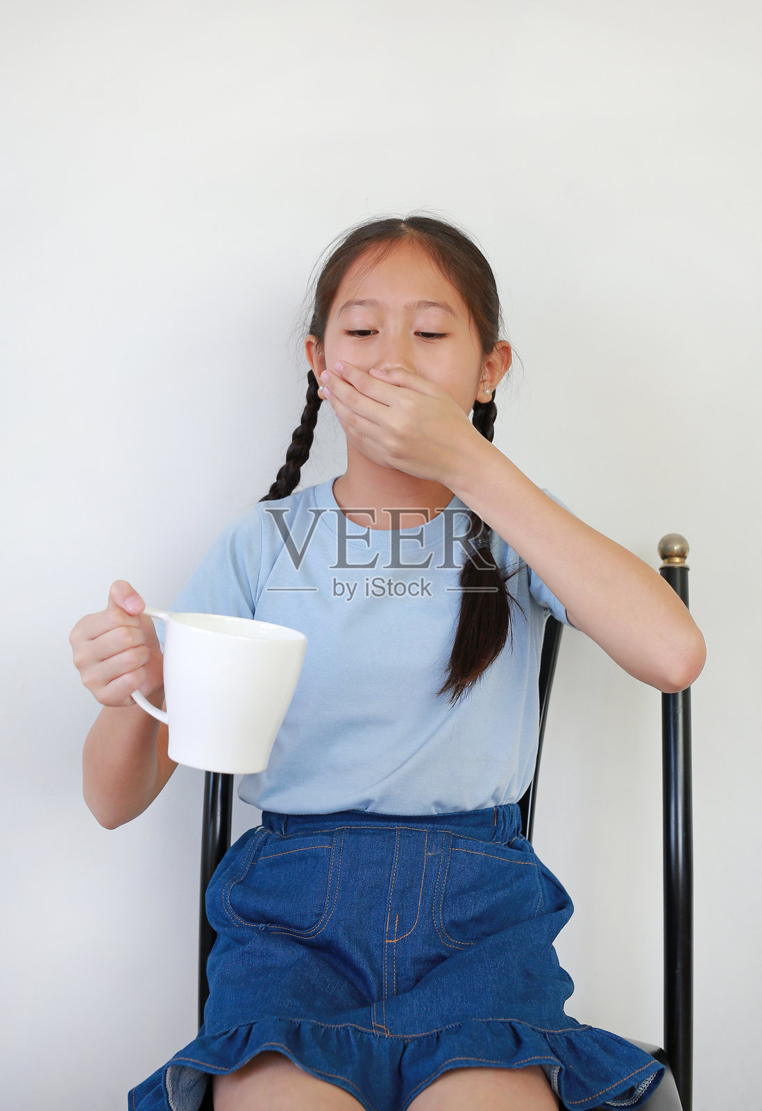 生病的亚洲女孩自己在服药。照片摄影图片