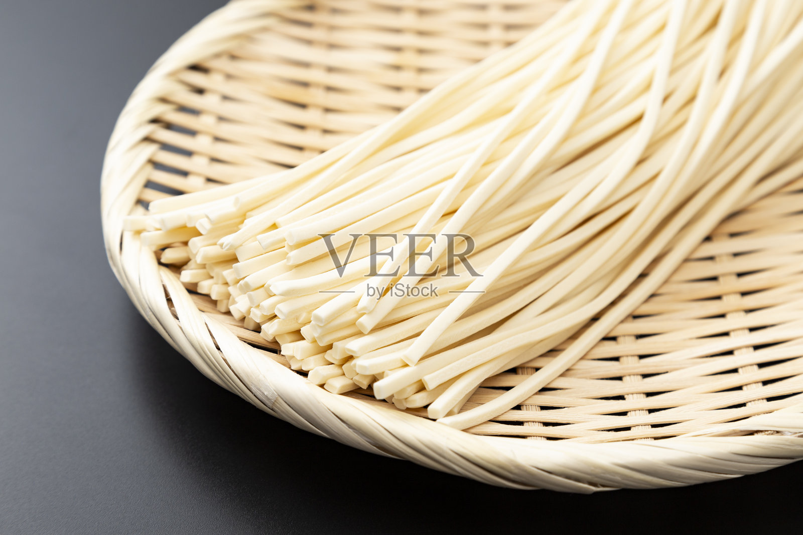 黑色背景上的生乌冬面。照片摄影图片