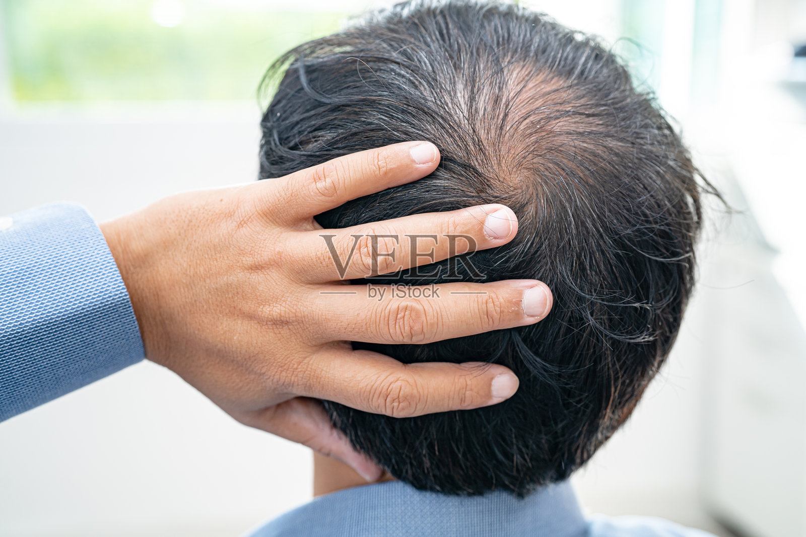 成熟的亚洲商务男士,头顶秃顶,开始出现脱发,聪明而积极的办公室工作者。照片摄影图片