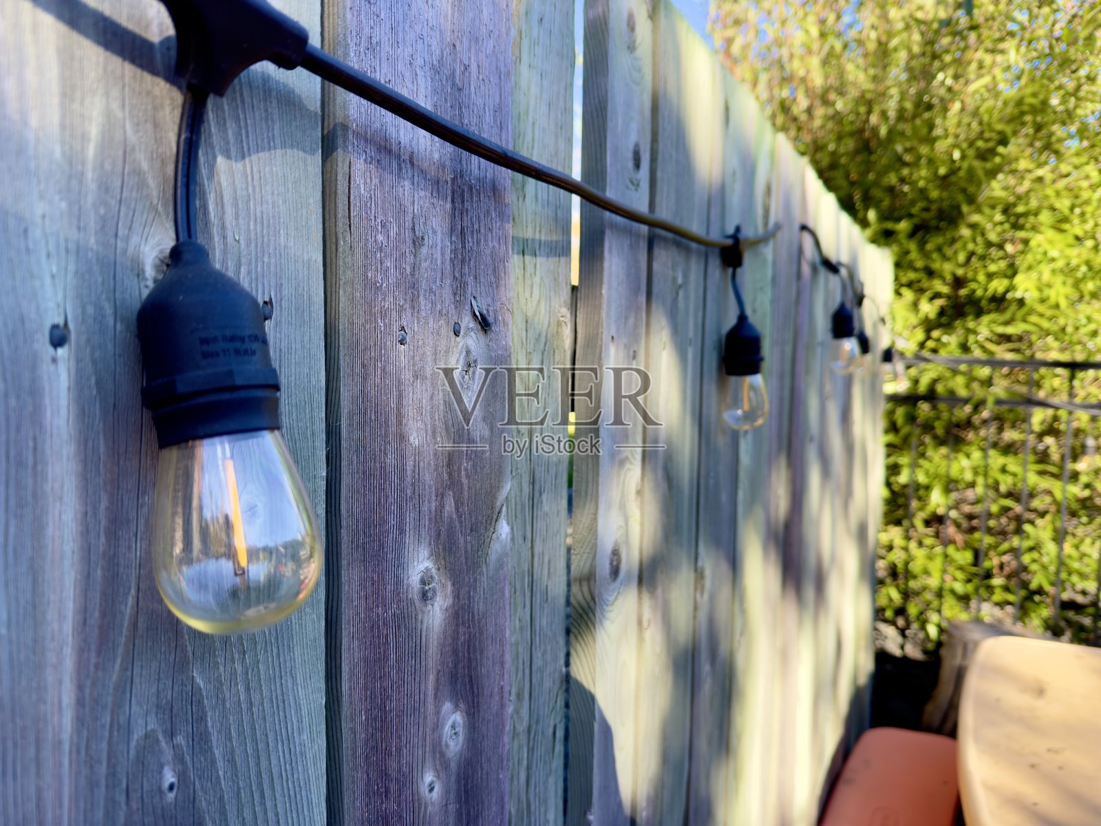 挂在木栅栏上的灯泡花环照片摄影图片