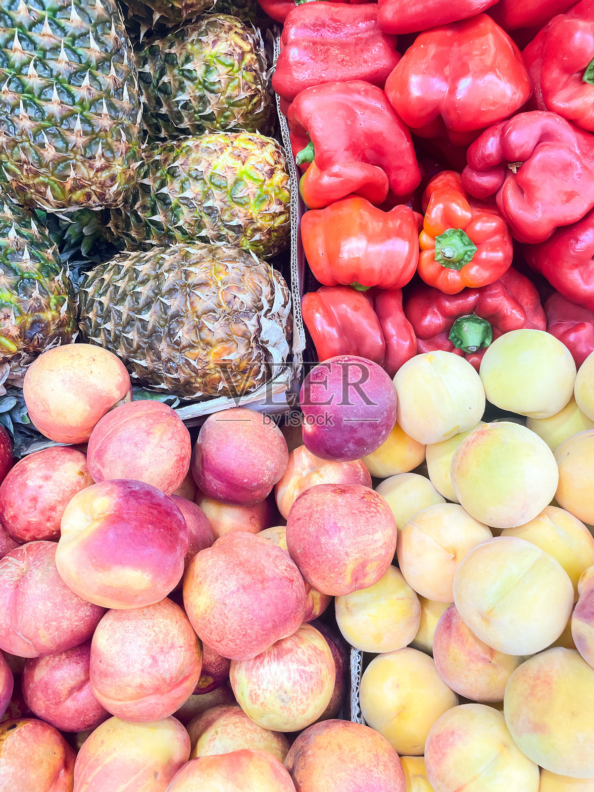 九月份应季的水果和蔬菜:菠萝、红椒、油桃和桃子。照片摄影图片