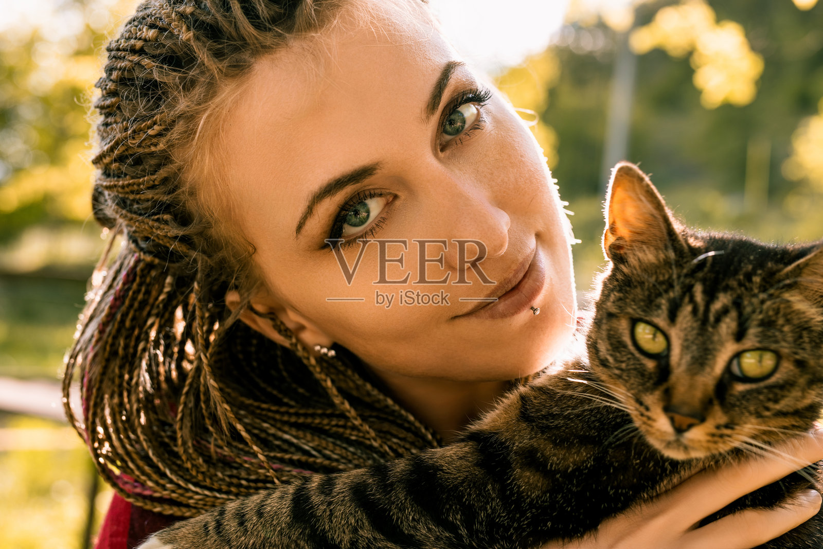 年轻女子在户外拥抱一只虎斑猫照片摄影图片
