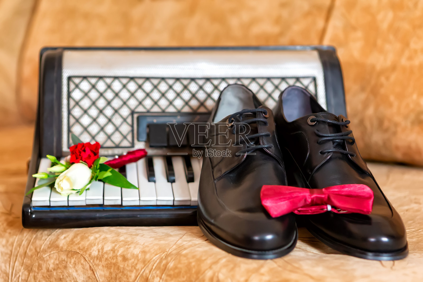 优雅的玫瑰花束和绿植在柔和灯光下的复古钢琴旁。照片摄影图片