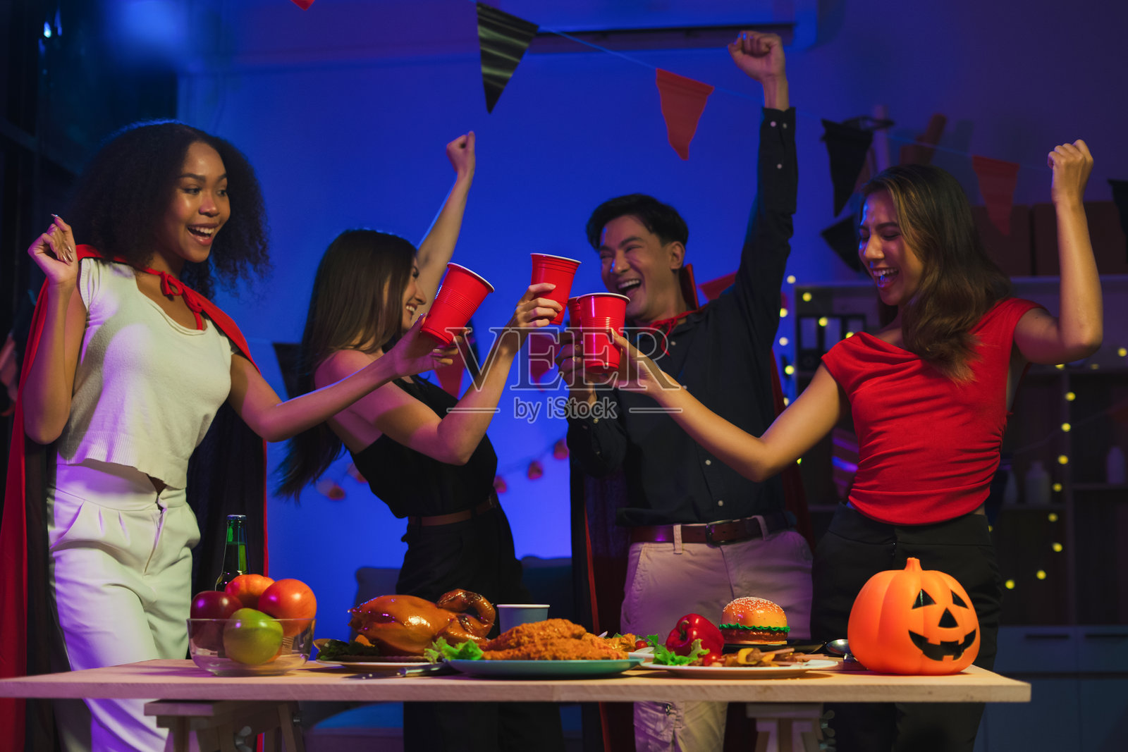 万圣节派对上庆祝的晚餐和一群人照片摄影图片