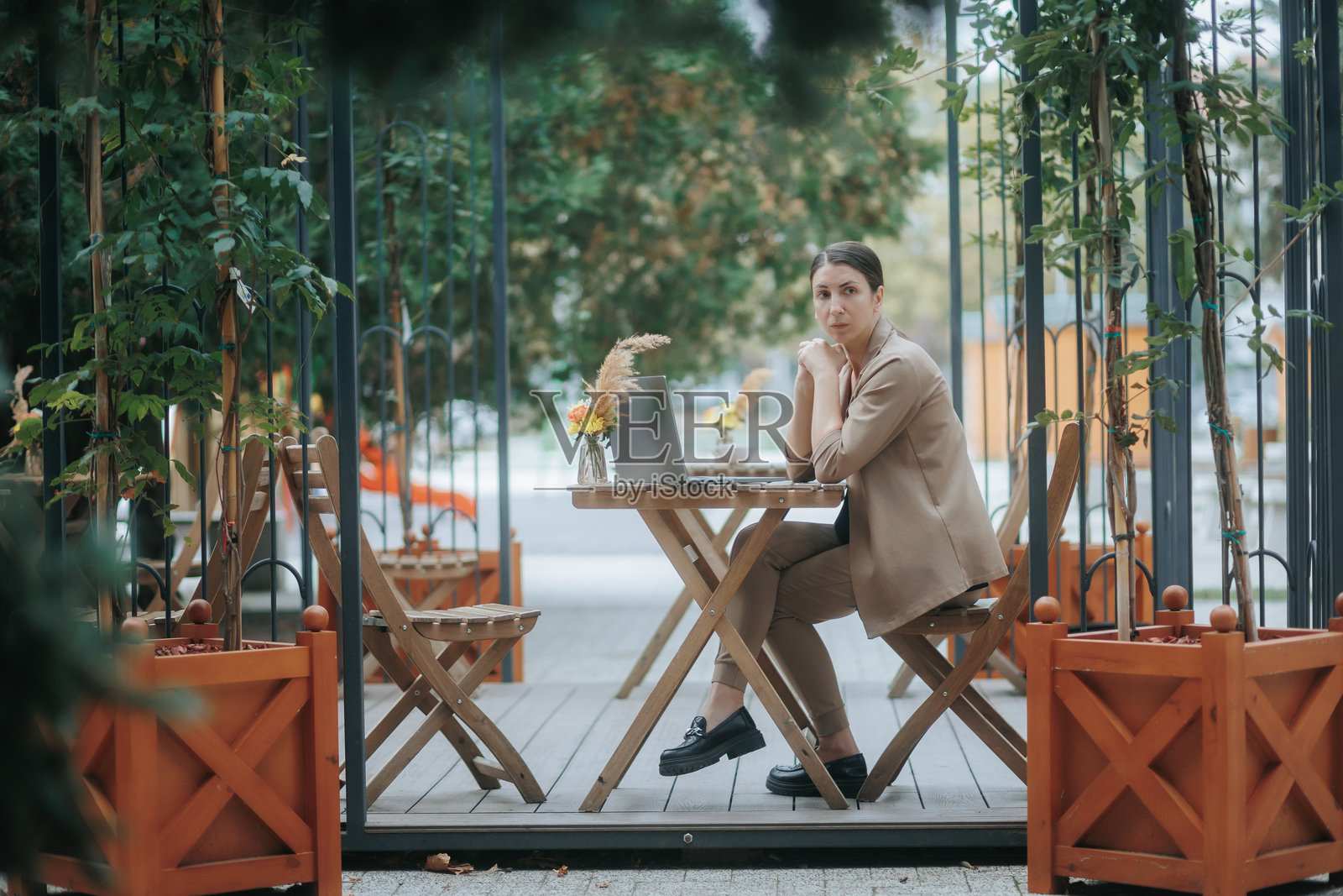 专注的年轻女性穿着西装,深思熟虑,在户外远程工作照片摄影图片