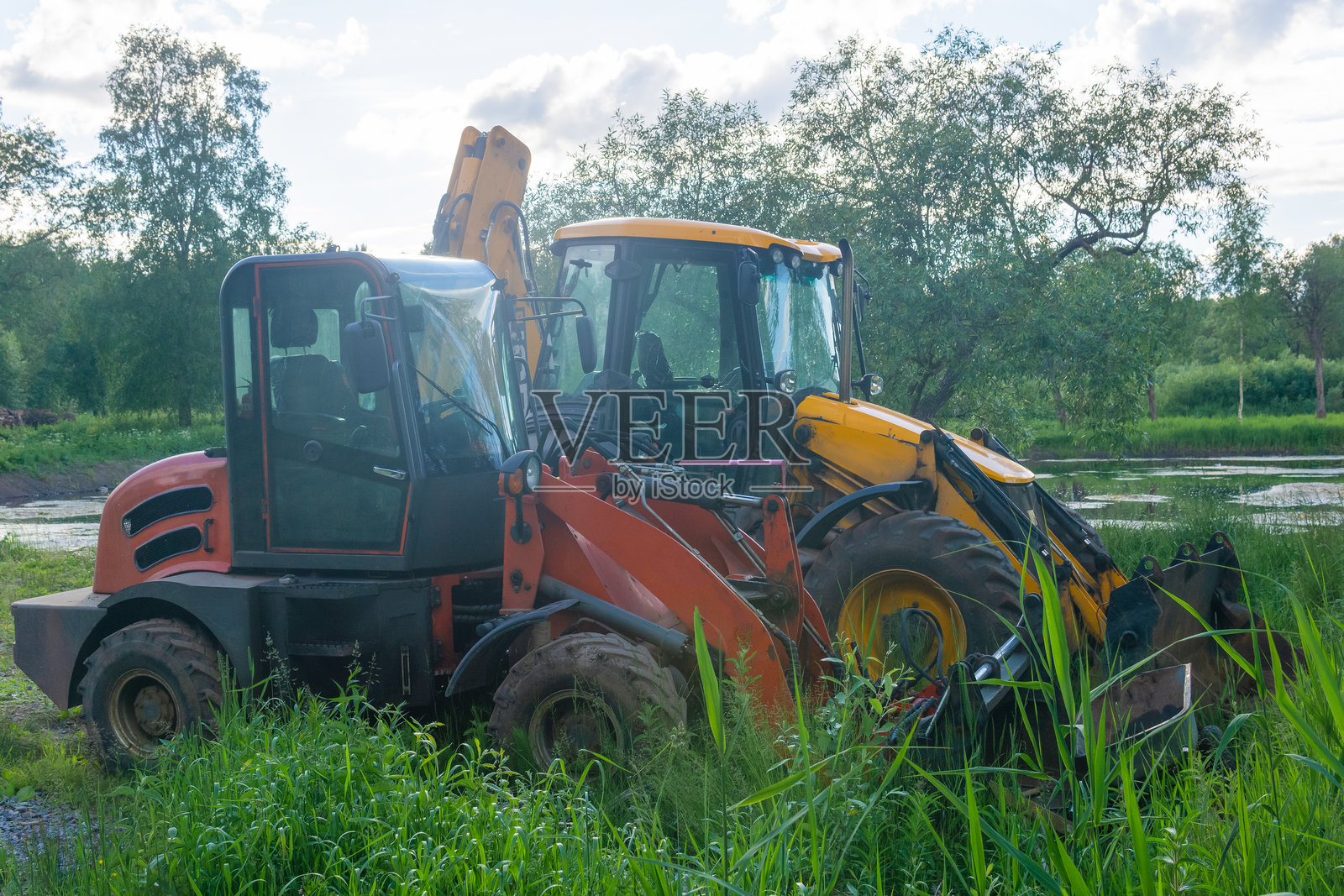 施工设备在草地上静静待命,准备开始园艺工作。照片摄影图片