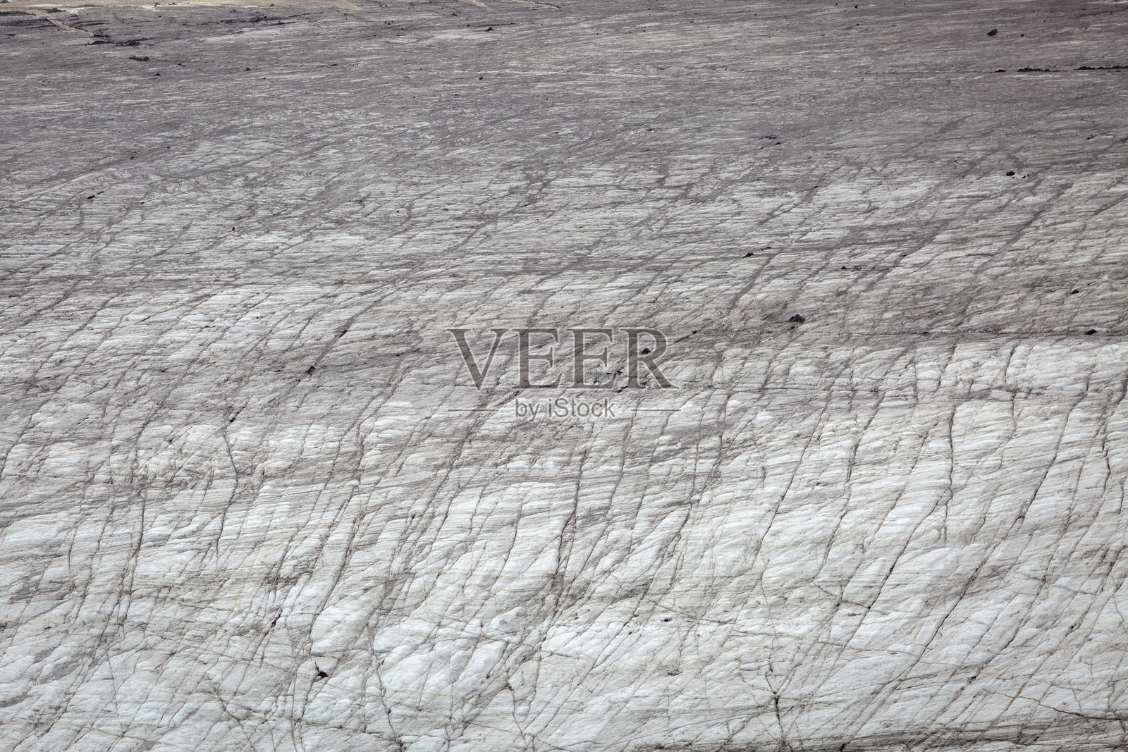 一片广阔的裂冰延展开来,点缀着微小的人影,显得在冰冷的景观中渺小无比。照片摄影图片