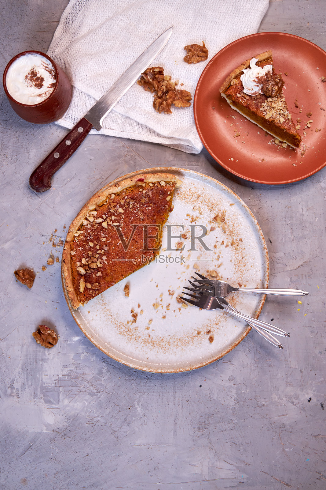 灰色背景上陶瓷盘中的南瓜派切片。俯视图照片摄影图片