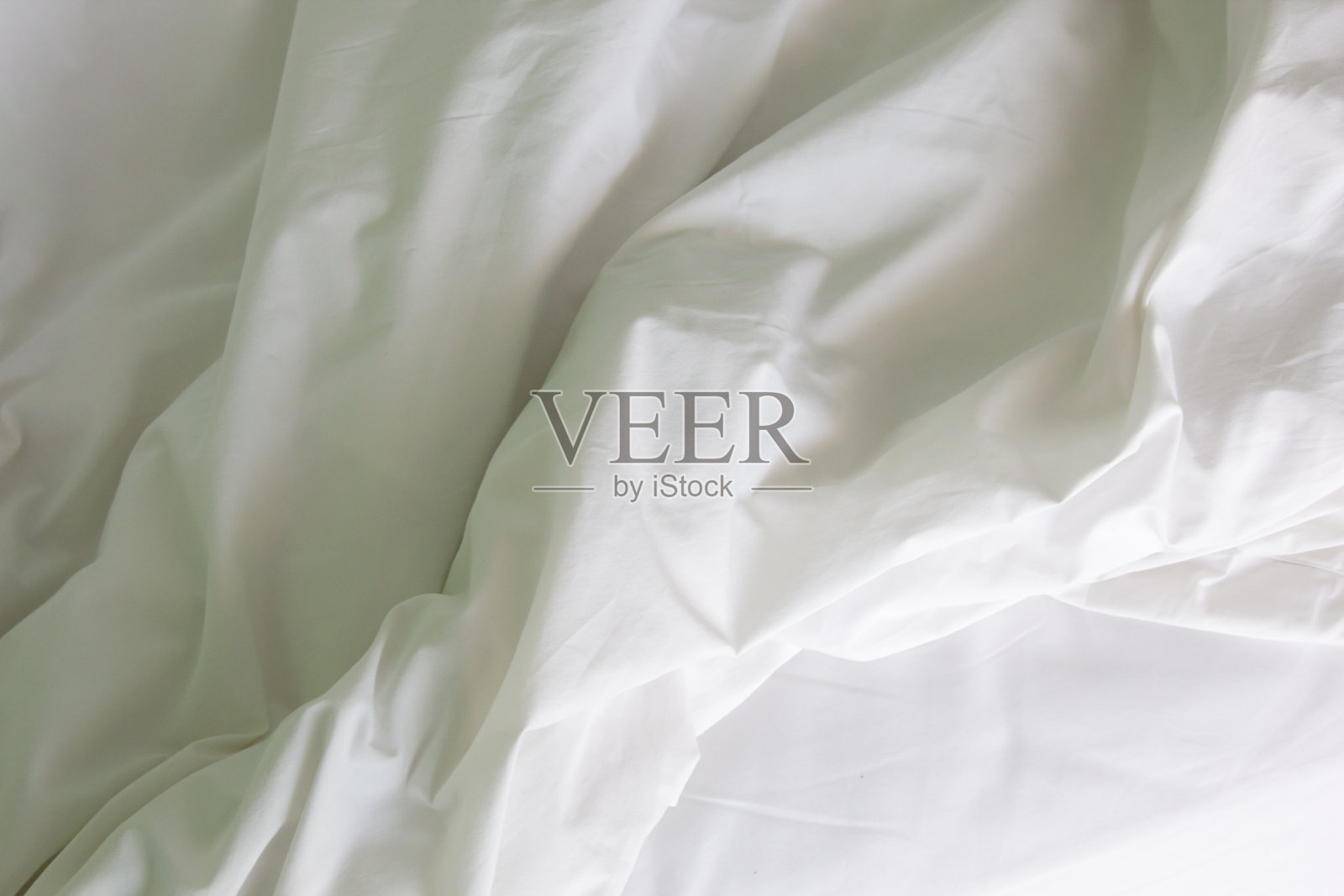 早上醒来后,皱巴巴的凌乱床单,长时间睡眠后的被子和毯子的细节。照片摄影图片