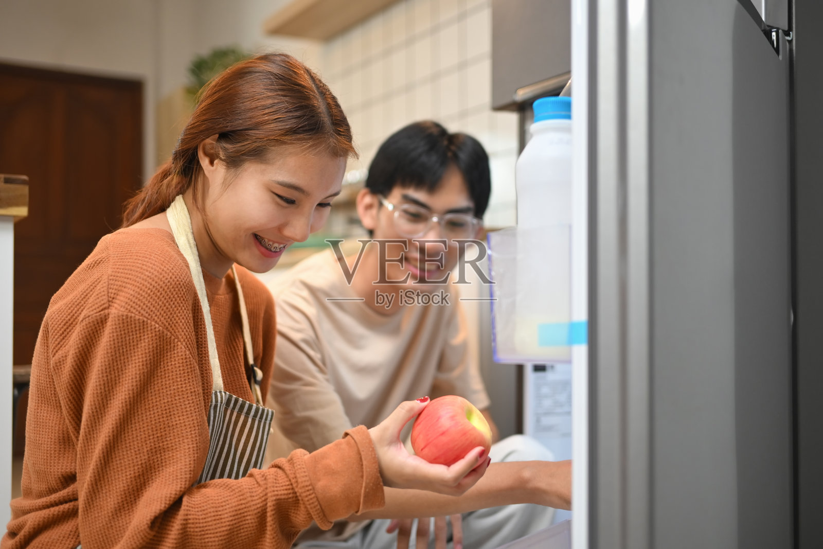 年轻情侣从冰箱里拿水果准备做健康早餐照片摄影图片